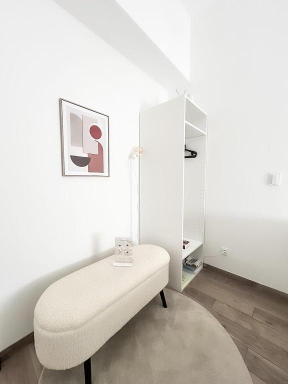 a white room with a white ottoman at Le Petit Cocon - Pause douceur in Cambrai