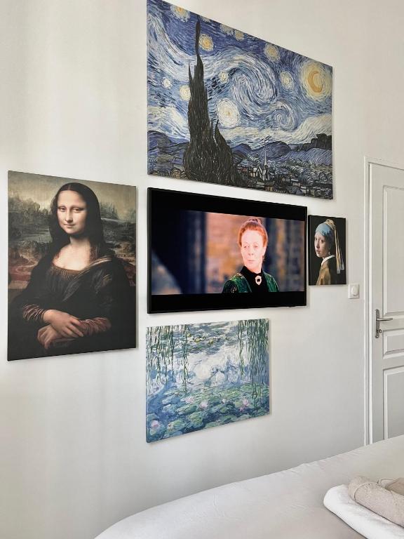 a room with four pictures on a wall at Le Petit Cocon - Pause douceur in Cambrai