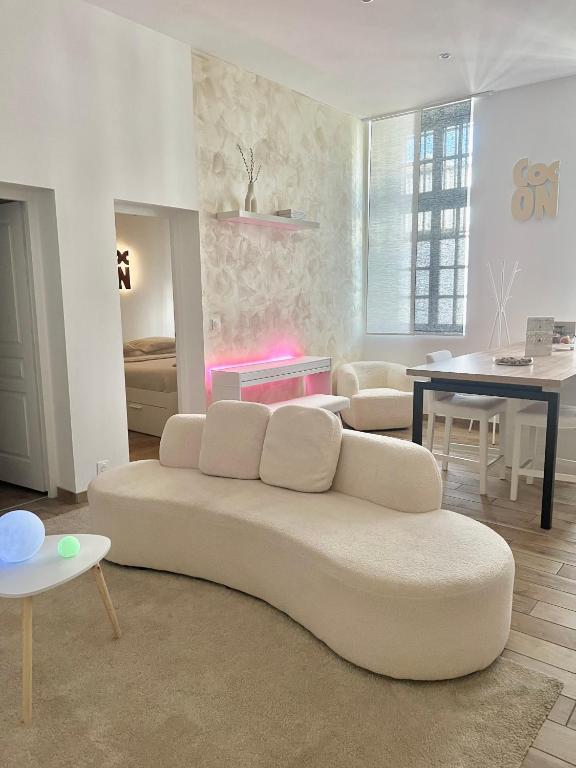 a white living room with a couch and a table at Le Petit Cocon - Pause douceur in Cambrai