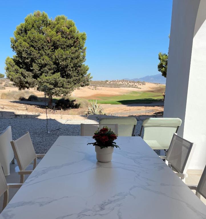a white table with a potted plant sitting on a patio at Casa Diana Golf in Murcia