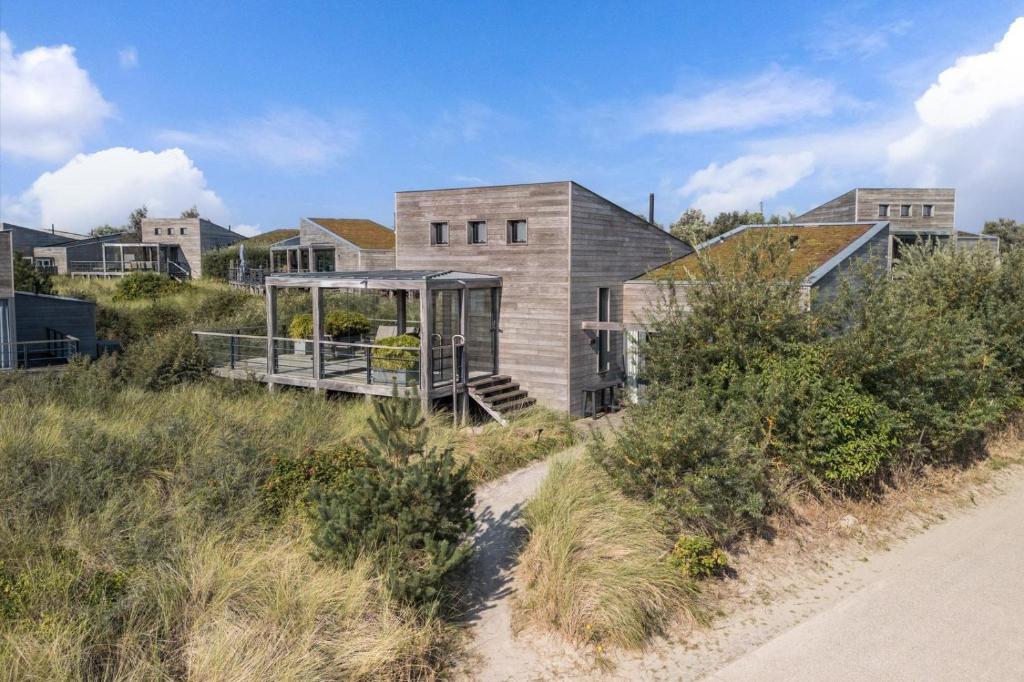 a house on a beach with a path at Super VIP Waterfront Villa - 4p - Waterzicht & Windbeschut Terras - Villa 42 in Ouddorp