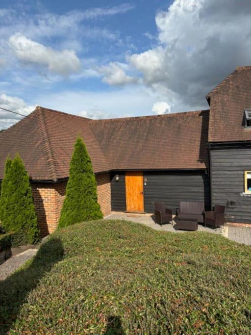 a house with a brown roof and a yard at 3 Coopers Cottages, Bodiam, East Sussex in Bodiam