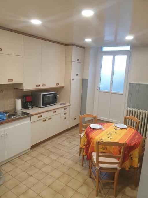 - une cuisine avec une table, une table et des chaises dans l'établissement Au Bonheur des dames, à Laval