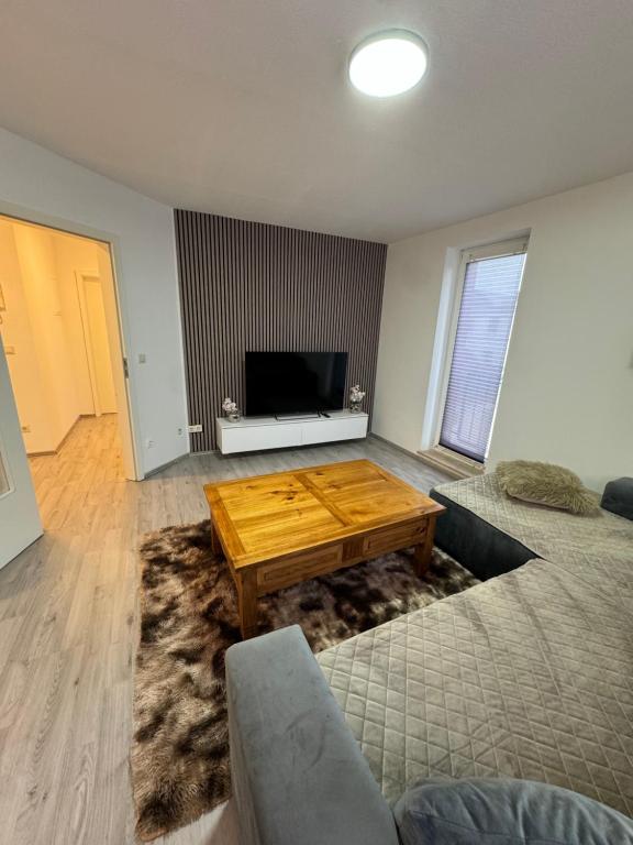 a living room with a coffee table and a television at Alex Apartments 3 in Solingen
