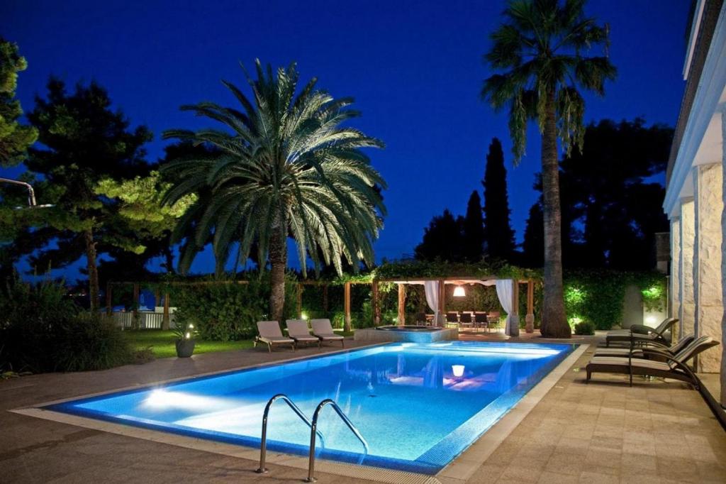 ein Swimmingpool in einem Hinterhof bei Nacht in der Unterkunft Kalliope House in Akrotiri