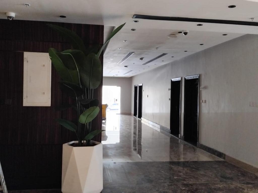 a hallway with a plant in a white planter at شقق ثري ستار للشقق المخدومة in Riyadh