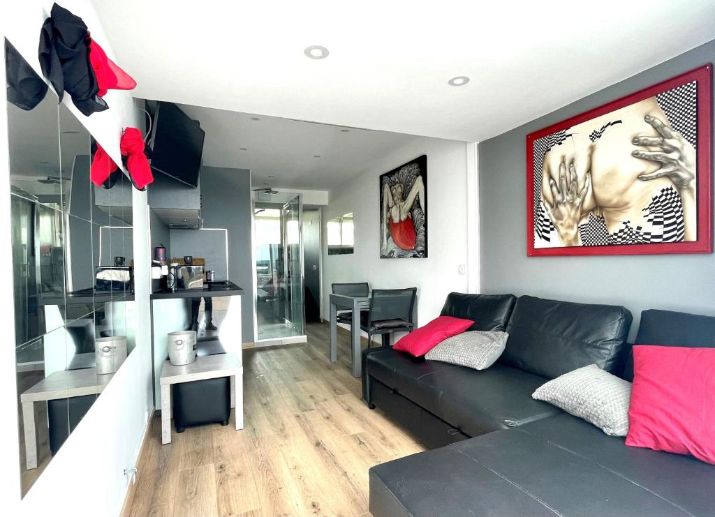 un salon avec un canapé noir et une table dans l'établissement COURSIVES RED-LIGHT 107 Vue Mer, au Cap d'Agde