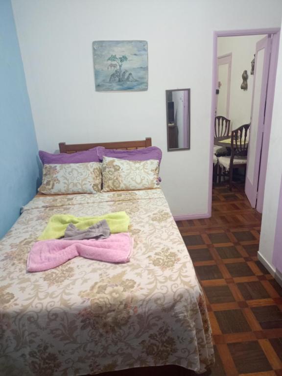 a bedroom with a bed with two towels on it at Lolita House in Rio de Janeiro