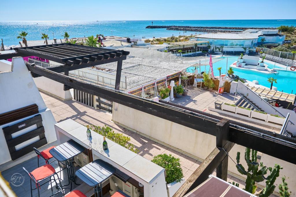une vue aérienne d'un complexe hôtelier avec piscine et l'océan dans l'établissement COURSIVES RED-LIGHT 108 Vue Mer, au Cap d'Agde