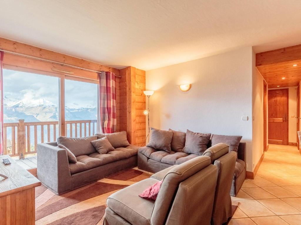 un salon avec un canapé et une grande fenêtre dans l'établissement Appartement 4 chambres, skis aux pieds, parking, animaux admis, WIFI - FR-1-352-82, à Arc 1800