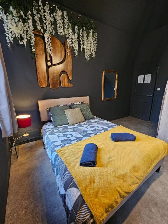 une chambre avec un lit avec deux oreillers bleus dessus dans l'établissement Le Velvet, à Hénin-Beaumont