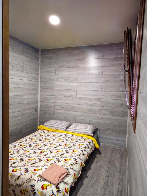 a bed in a room with a wooden wall at Мій Еко Готель in Fominka