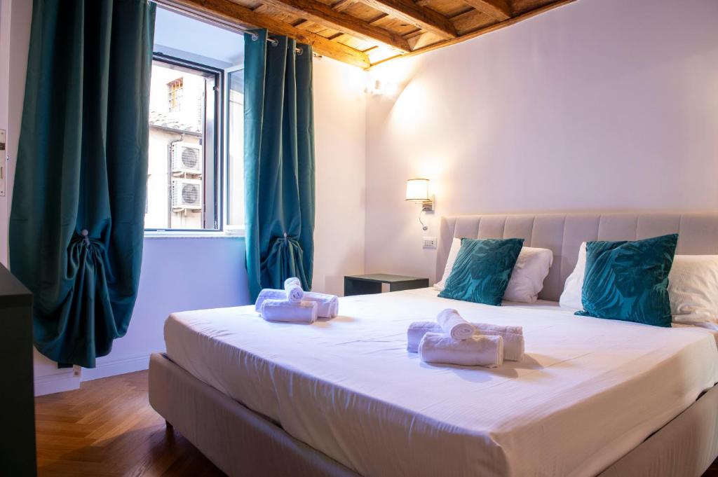 a bedroom with a large white bed with blue pillows at Costaguti Holiday Apartment in Rome