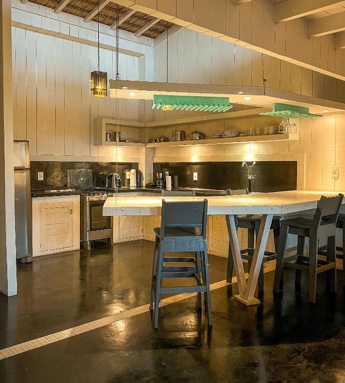 a large kitchen with a large table and chairs at As Palhas in Icaraí