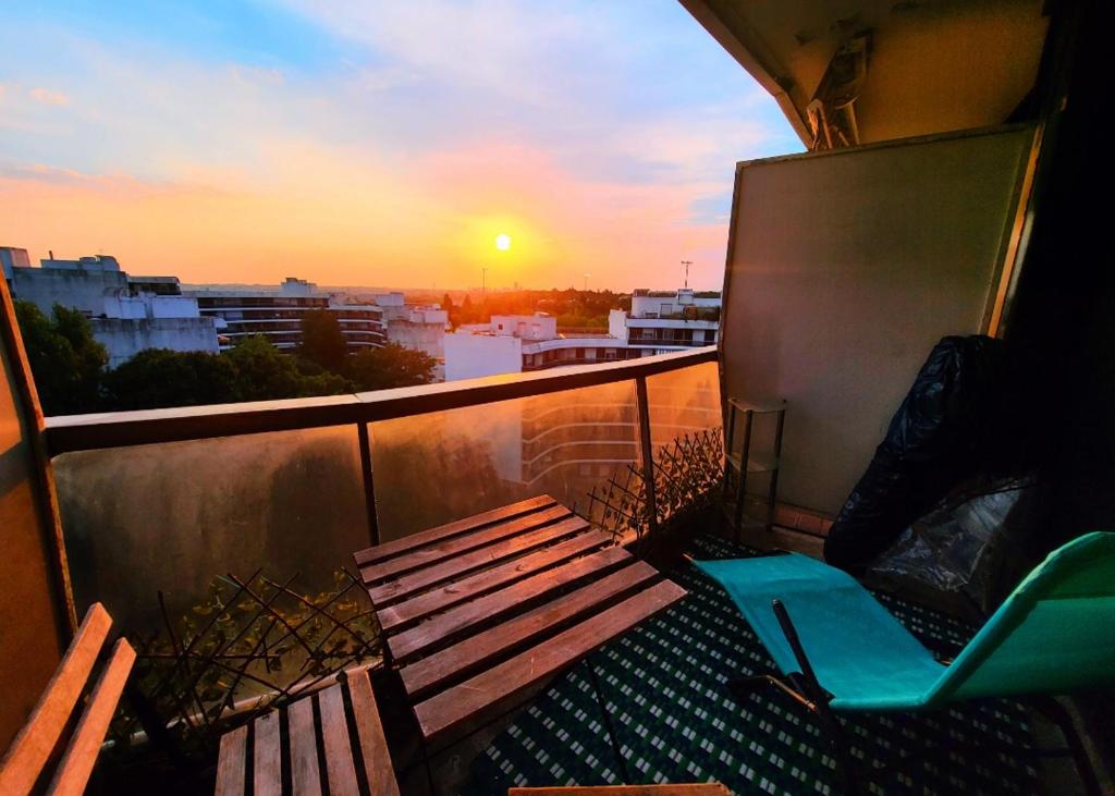 ein Balkon mit einer Bank und einem Stuhl bei Sonnenuntergang in der Unterkunft Studio meublé vue tour Eiffel et tout Paris in Saint-Maurice