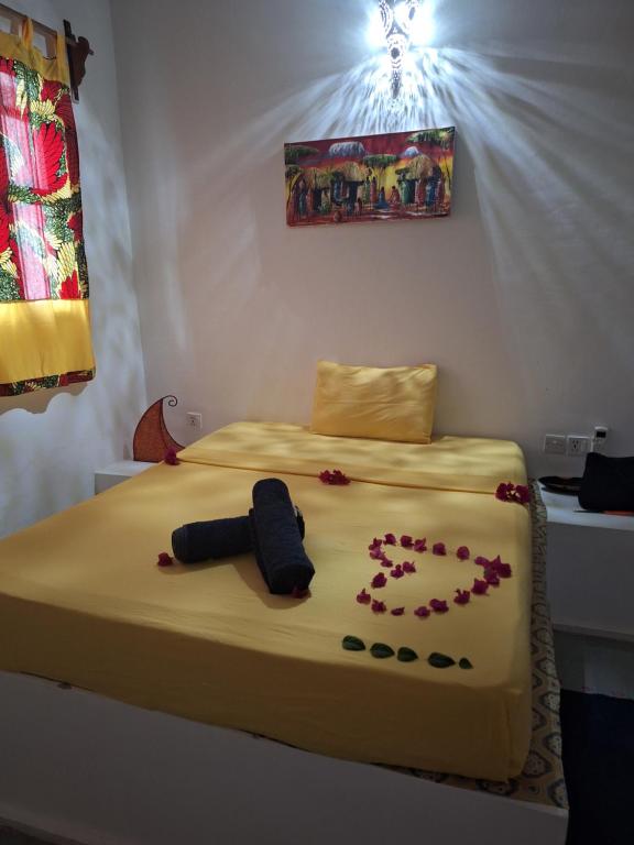 a bed with flowers on it in a room at La CASETTA A ZANZIBAR B&B in Uroa