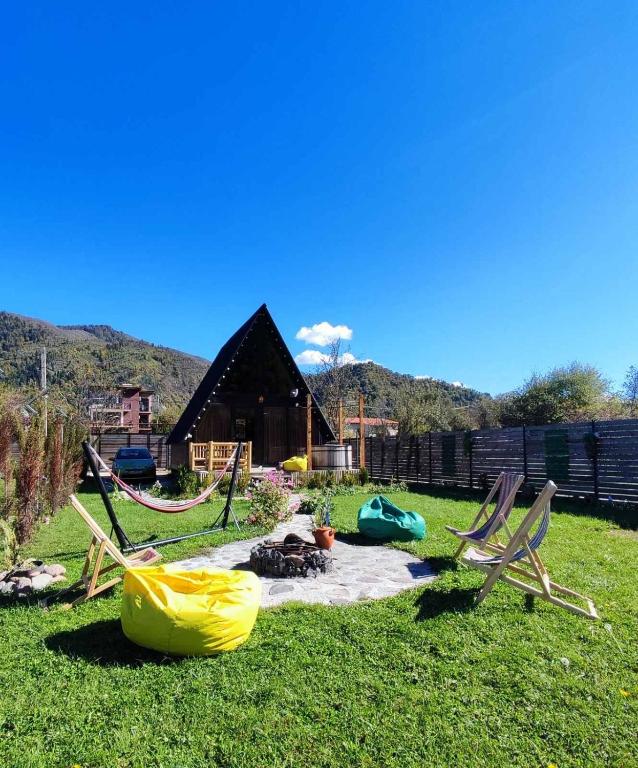 a group of chairs and a fire pit in the grass at Borjomi Story in Borjomi
