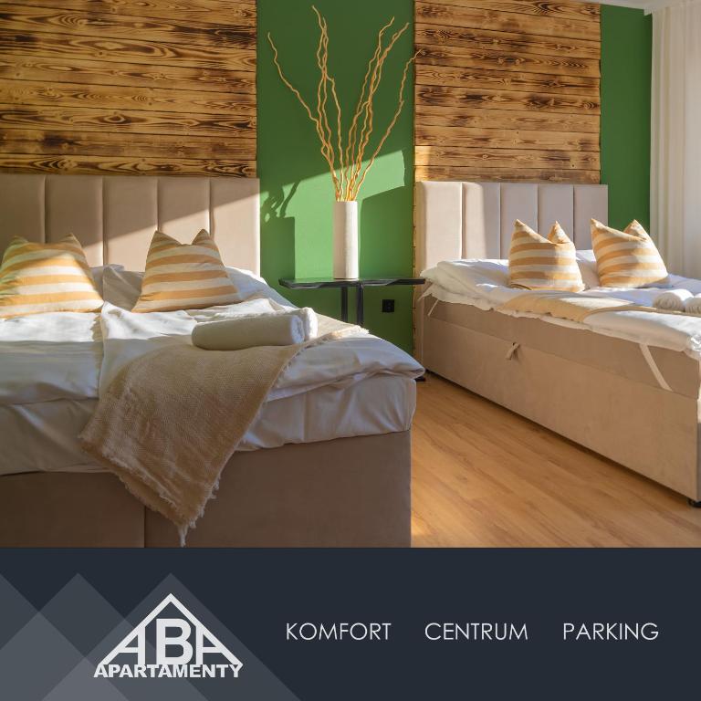 two beds in a room with green walls at ABA Apartamenty Comfort Family in Krynica Zdrój