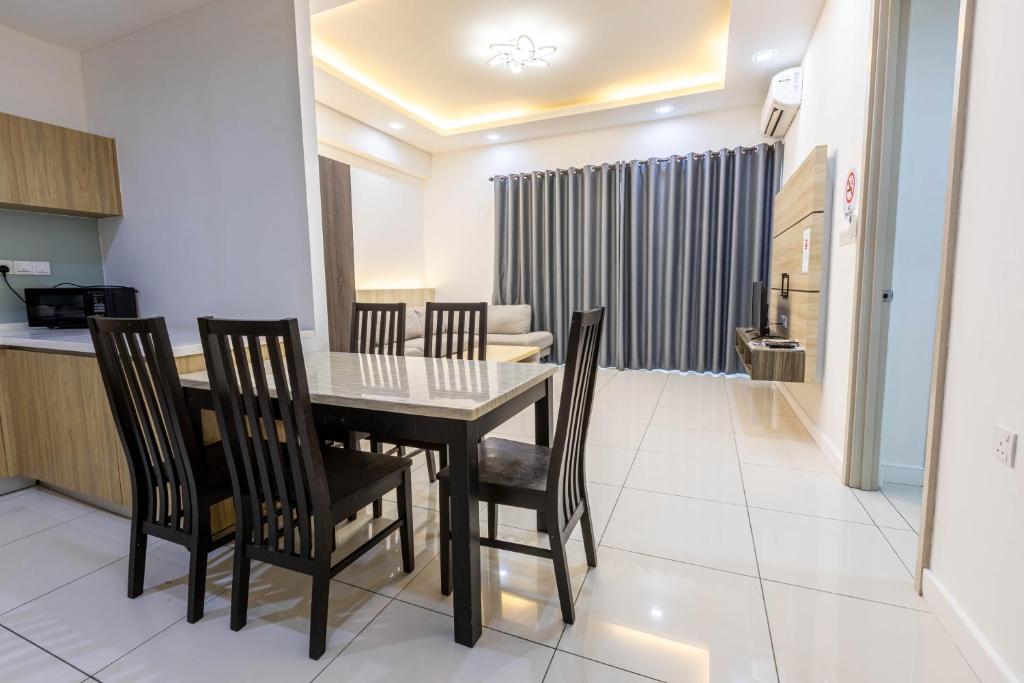 a dining room and kitchen with a table and chairs at Miri Times Square Serviced Apartment in Miri