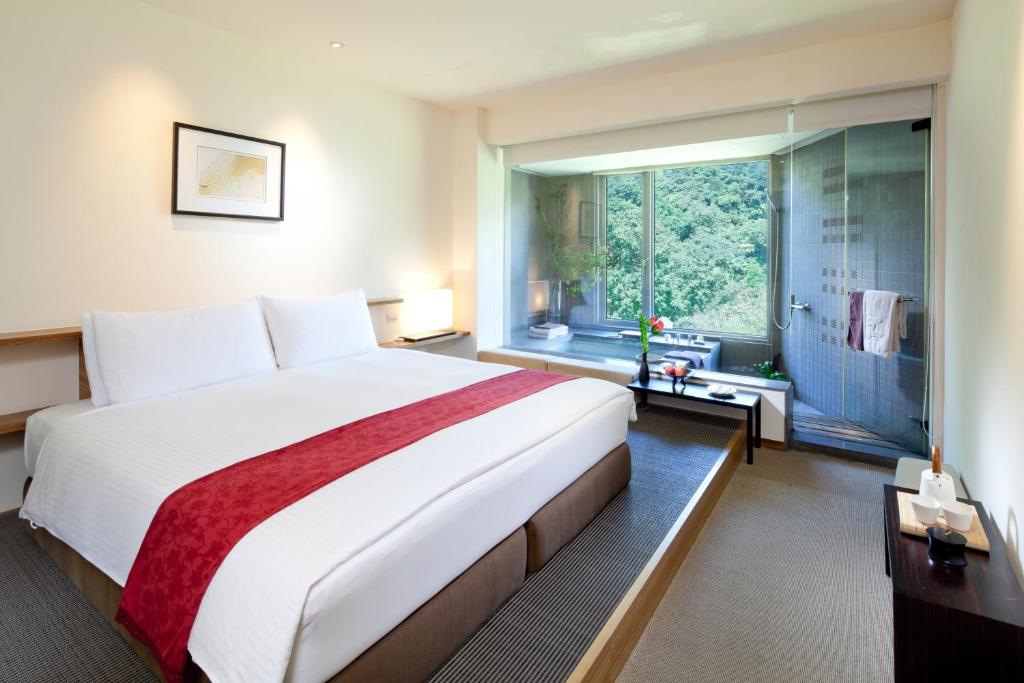 a bedroom with a large bed and a large window at CHECK inn Select Taipei Yamgmingshan in Taipei