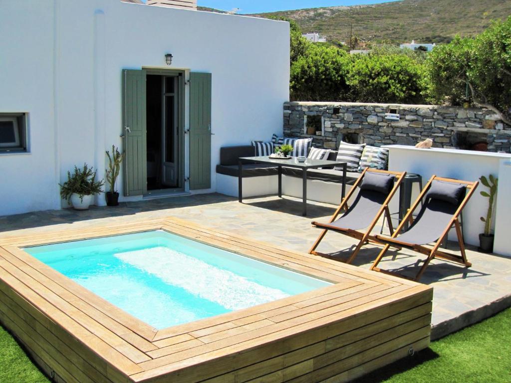 patio z basenem, 2 krzesłami i stołem w obiekcie The old barn, Naousa Paros w mieście Nausa