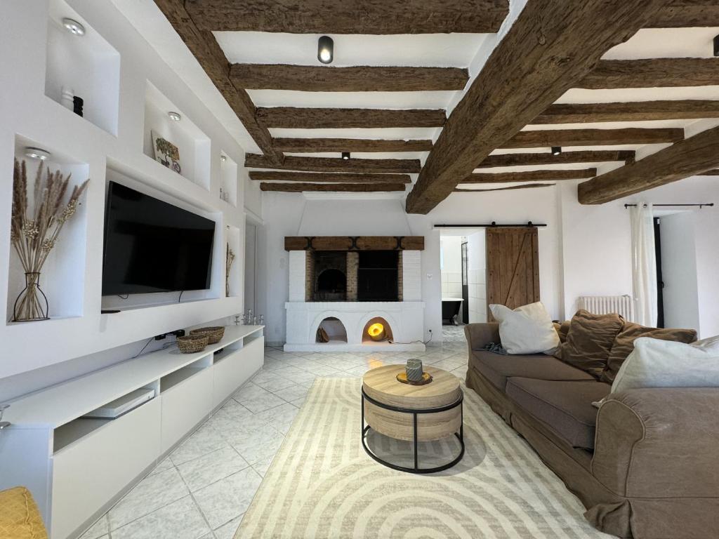 Il comprend un salon doté d'un canapé, d'une télévision et d'une cheminée. dans l'établissement Le Saltimbanque - 6 pers - Campagne - Rêve au Mans, à Mansigné