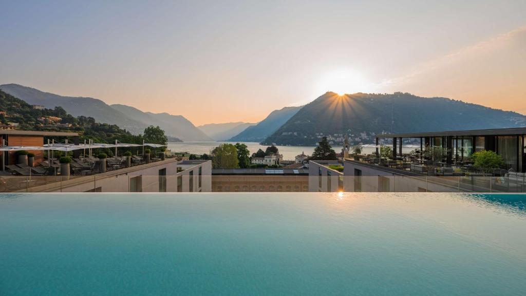 a large swimming pool with a view of a mountain at Hilton Lake Como in Como