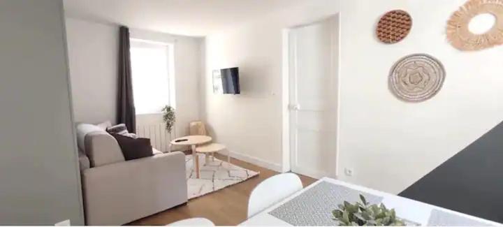 un salon blanc avec un canapé et une table dans l'établissement L'idylle dieppoise, à Dieppe