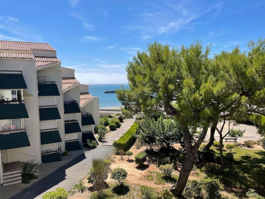 un immeuble d'appartements avec un arbre devant dans l'établissement Chez chris, à Sète
