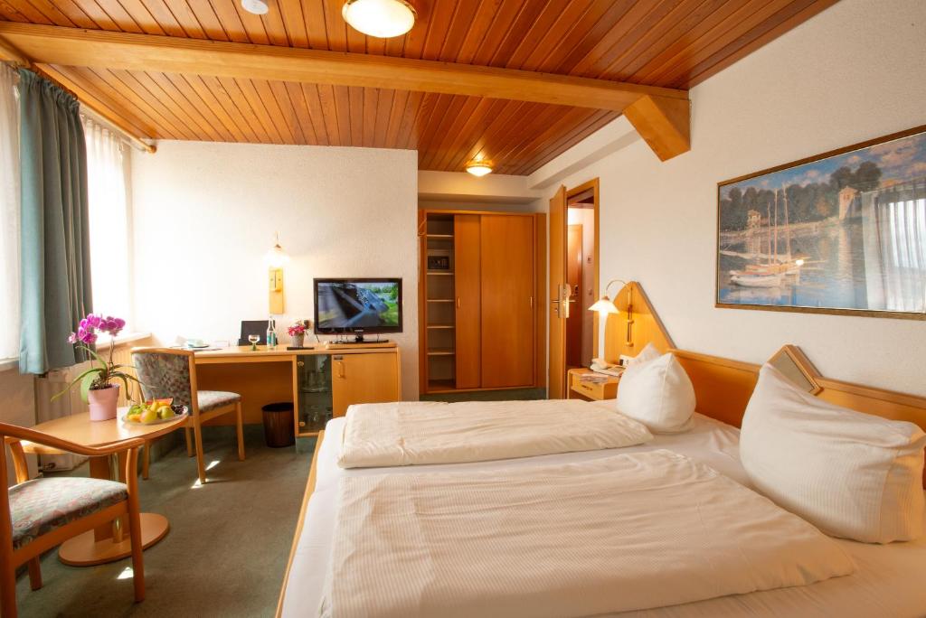 a hotel room with a bed and a desk at Hotel und Restaurant zum Schiffchen in Wolfhagen