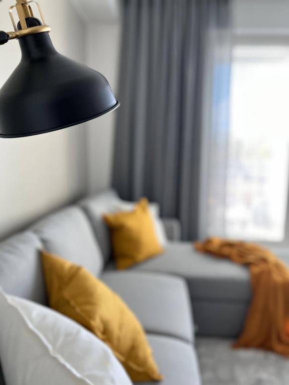 a living room with a couch and a black lamp at Kampuksen Tähti in Pori