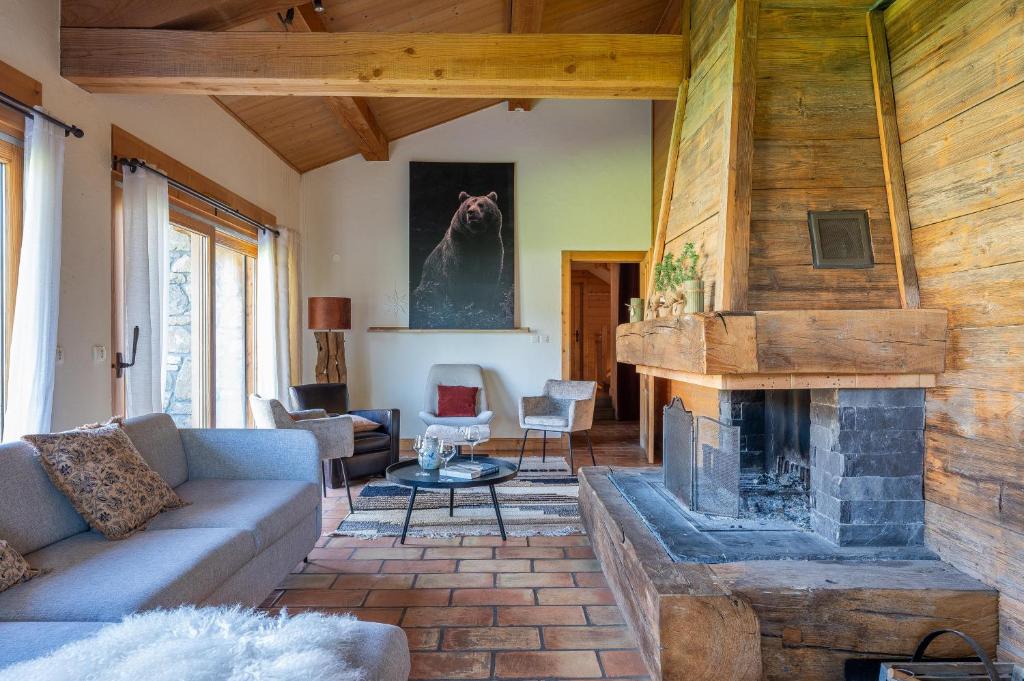 un salon avec un canapé et une cheminée dans l'établissement Chalet Mouflon des Neiges, aux Gets