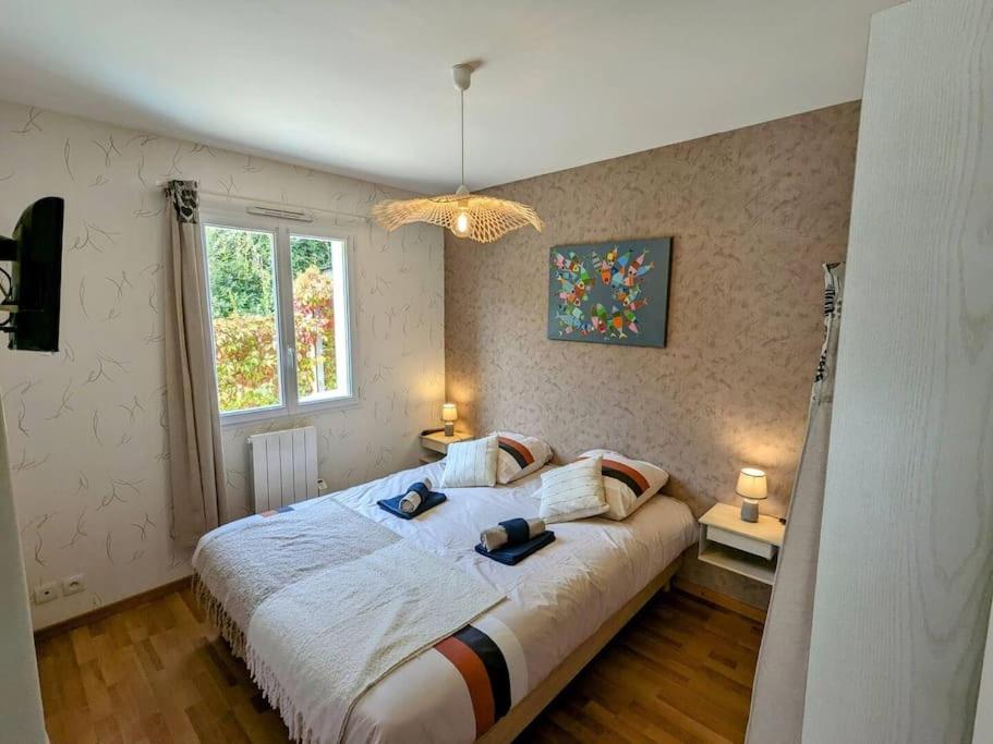 カマレ・シュル・メールにあるMaison des Bruyères, proche plages et portの大きなベッドと窓のある寝室