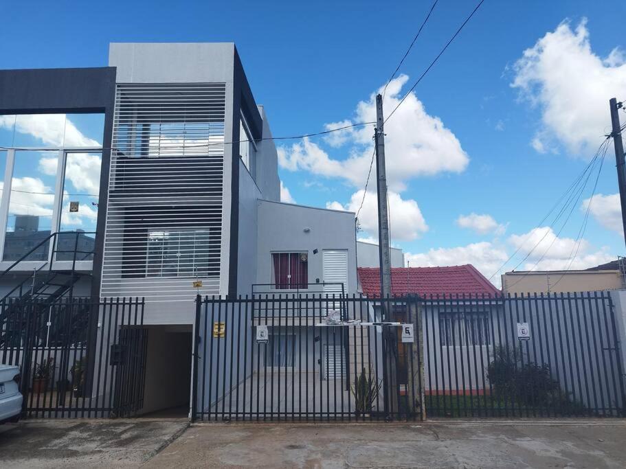 蓬塔格罗萨Casa central 74 com ótima localização的一栋前面有栅栏的白色房子