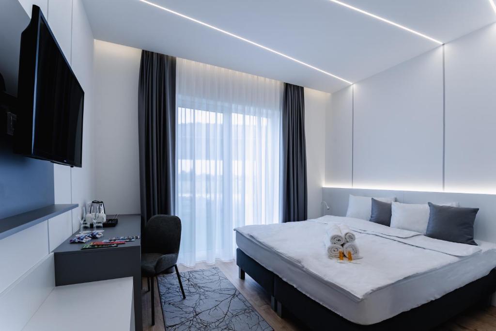 a bedroom with a bed and a desk and a television at Airport Noa Panzió in Vecsés