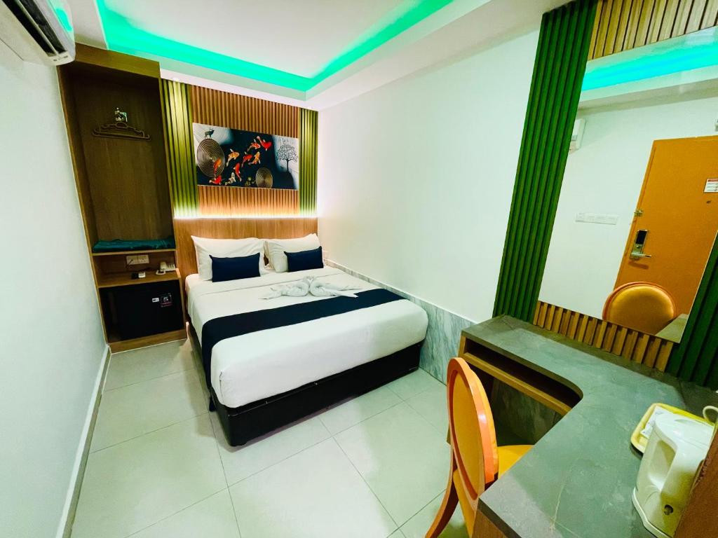 A compact guest room showing a double bed beside a narrow desk and dressing mirror.