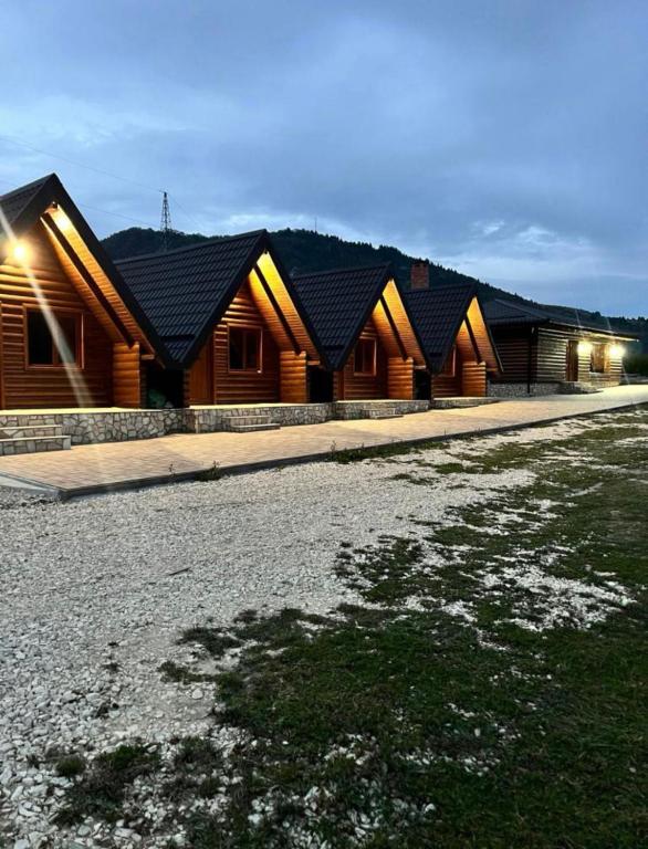 a row of wooden buildings with lights on them at Alpin Chalet in Rucăr