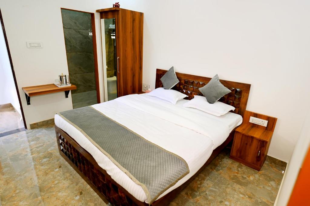 Un dormitorio con una cama grande con sábanas y almohadas blancas. en Karni Divine Haveli, en Bikaner