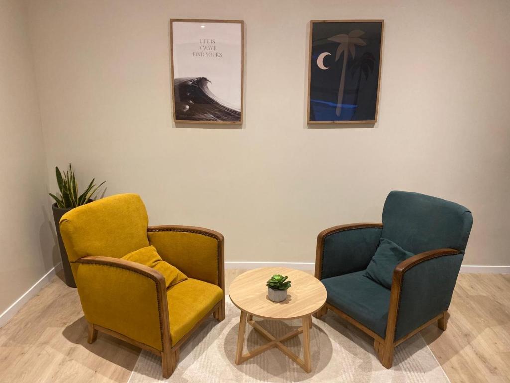 une salle d'attente avec deux chaises et une table dans l'établissement Charmant studio pont de Kerino-Chorus-Conleau, à Vannes
