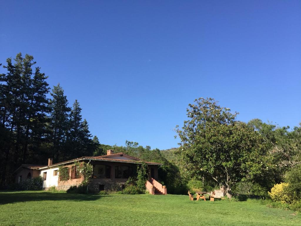 une maison sur une pelouse avec des chiens dans la cour dans l'établissement Bon Accord, à Ascochinga