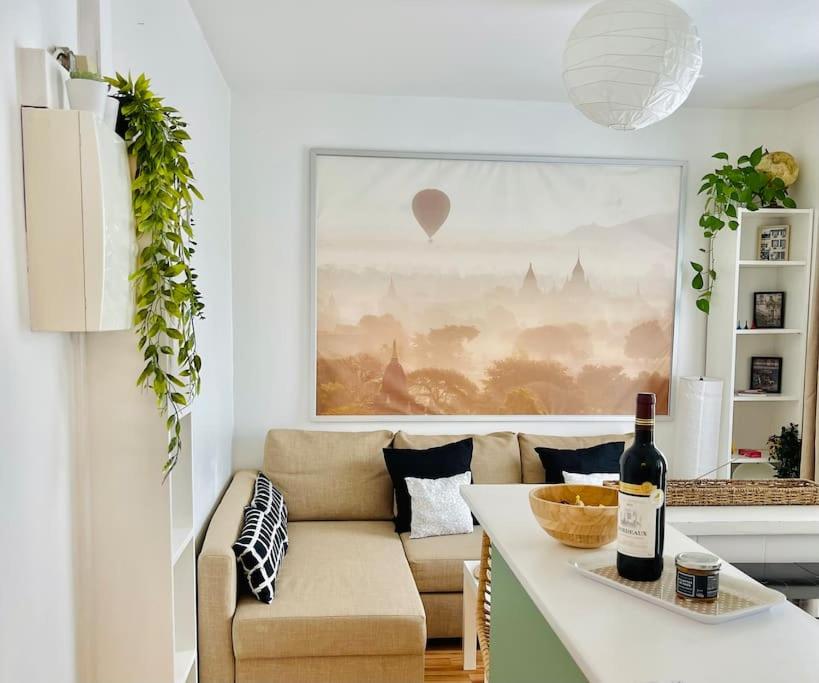 - un salon avec un canapé et une table avec une bouteille de vin dans l'établissement Charming Appartment - Paris Stade de France, à Saint-Denis