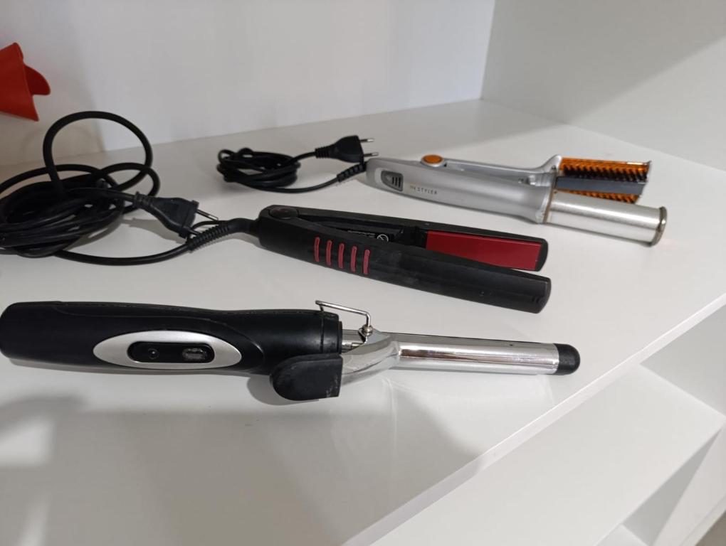 a table topped with a hairbrush and a blow dryer at Agradável apartamento em bairro silencioso... in Camboriú