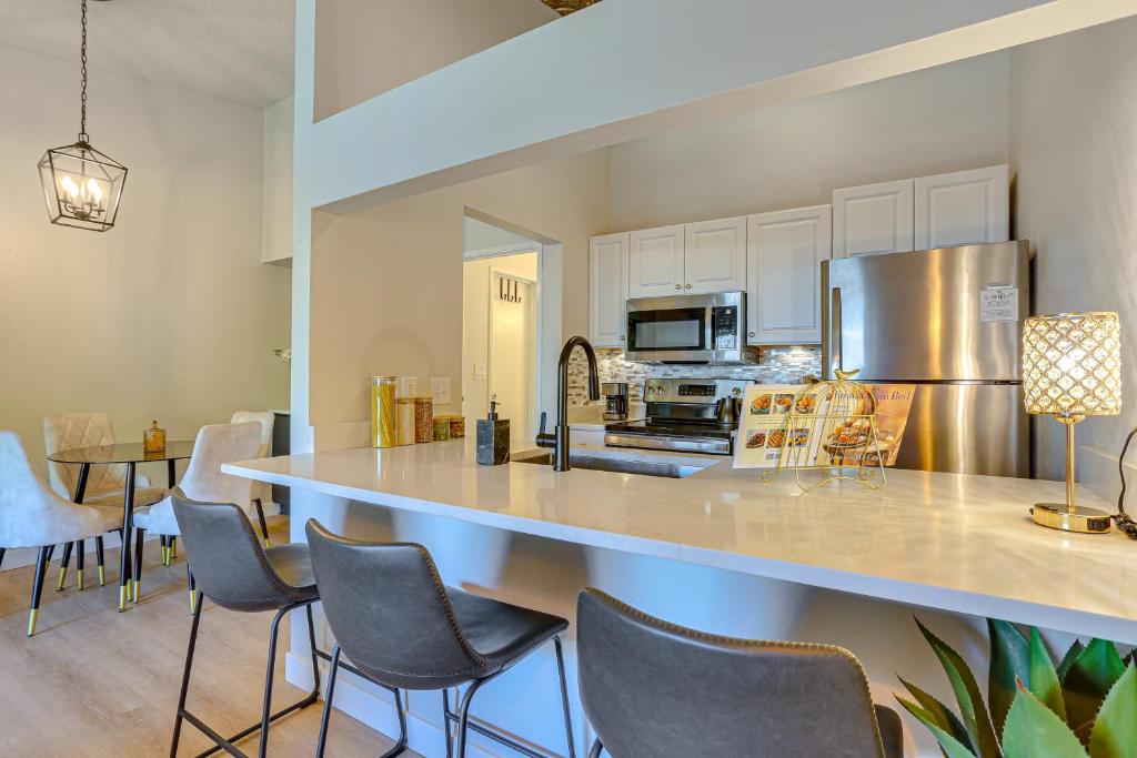 una cucina con un grande bancone con sedie di 1 Mi to Dtwn Condo with Pool Access in Castle Rock a Castle Rock