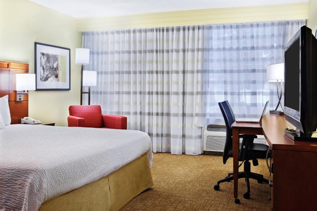 Una habitación de hotel con una cama, un escritorio y una computadora. en Heritage Place Houston Brookhollow, en Houston