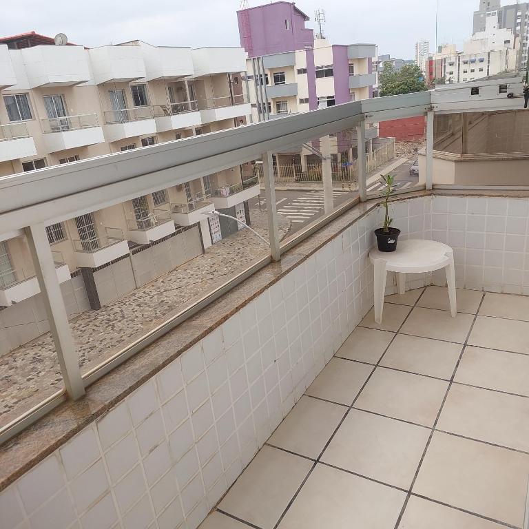a balcony with a table and a chair on a building at Apartamento Praia do Morro em Guarapari in Guarapari