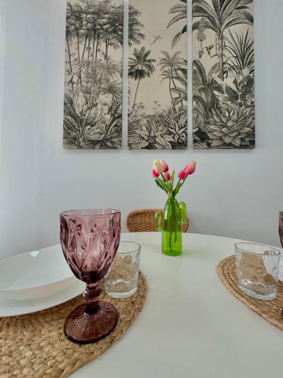 a table with a vase with pink flowers in it at Casa Almanzora, apartamento de 1 dormitorio, wifi, parking gratuito in Zurgena