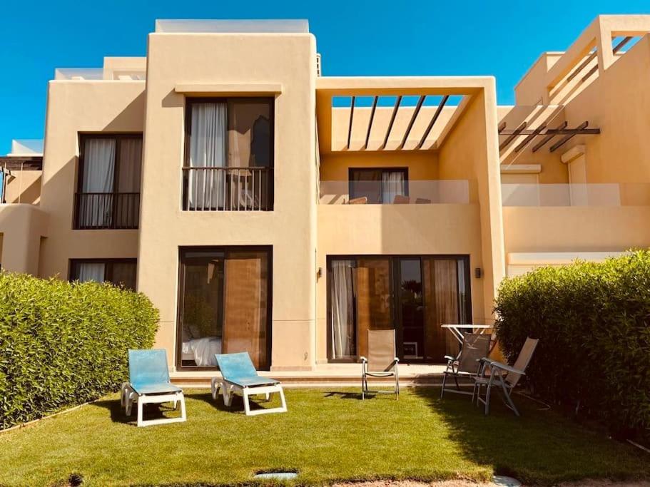 a house with two chairs and a lawn in front of it at Sunset Haven in Tawila TownHouse in Hurghada