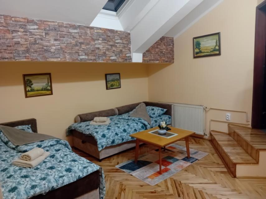 ein Wohnzimmer mit zwei Betten und einem Tisch in der Unterkunft Studio Apartman My Home in Novi Sad