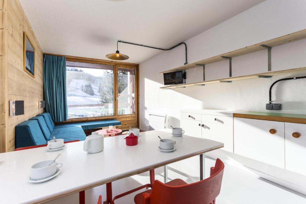 une cuisine et un salon avec une table et des chaises dans l'établissement Résidence Lauzieres - Studio 5 personnes pied des pistes MAE-5044, à Arc 1800