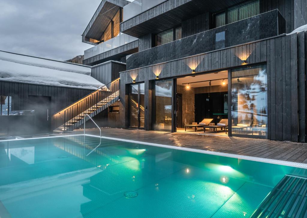 a swimming pool in front of a building at Paznauner Villen - Villa II in Kappl